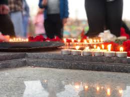 Жители Лиепаи несут свечи к месту снесенного властями памятника защитникам